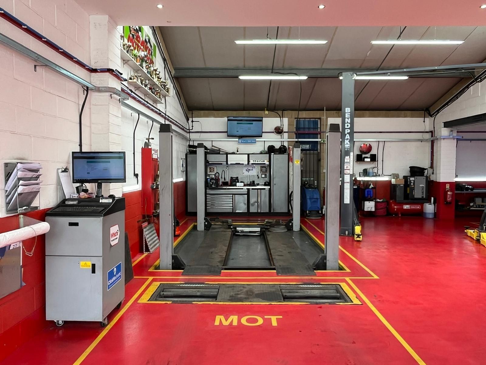 The MOT bay at TD Garage Services: test lane with roller brake tester, red floor and MOT painted in yellow